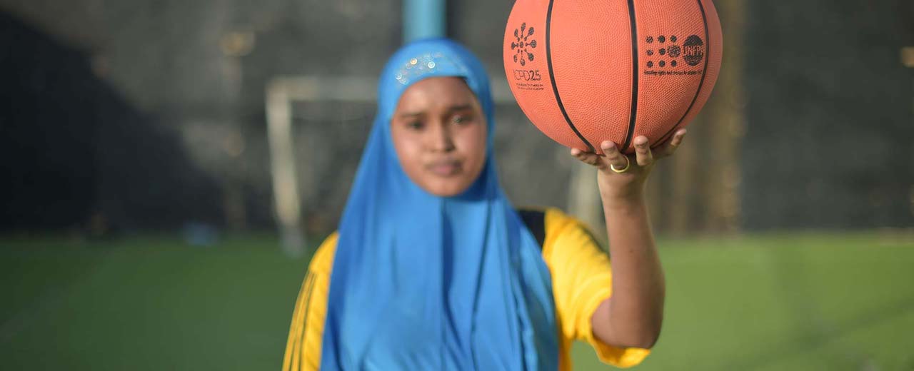 A young girl holds a basketball. 