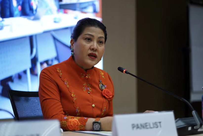 The photo shows Ratchada Jayagupta speaking into a microphone.