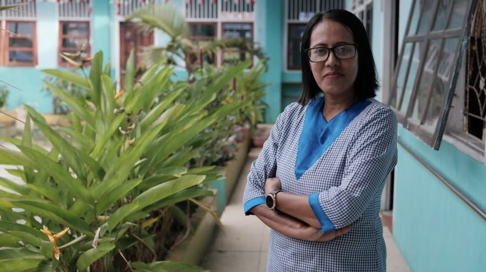 The photo shows reproductive health advocate Yuliana Yolanda Luhulima standing in the courtyard of a building.