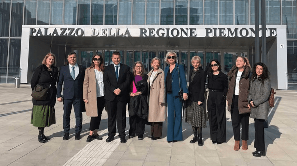 The photo shows 11 participants in the study standing in front of the glass-fronted Palazzo della Regione Piemonte, a regional government office in Turin, Italy.