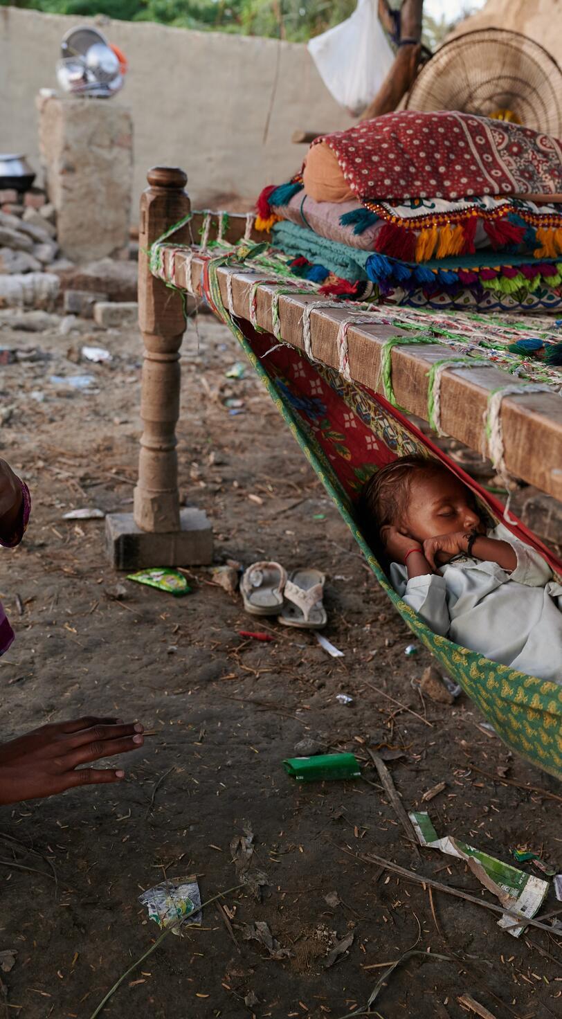 A woman sits with her sleeping child.