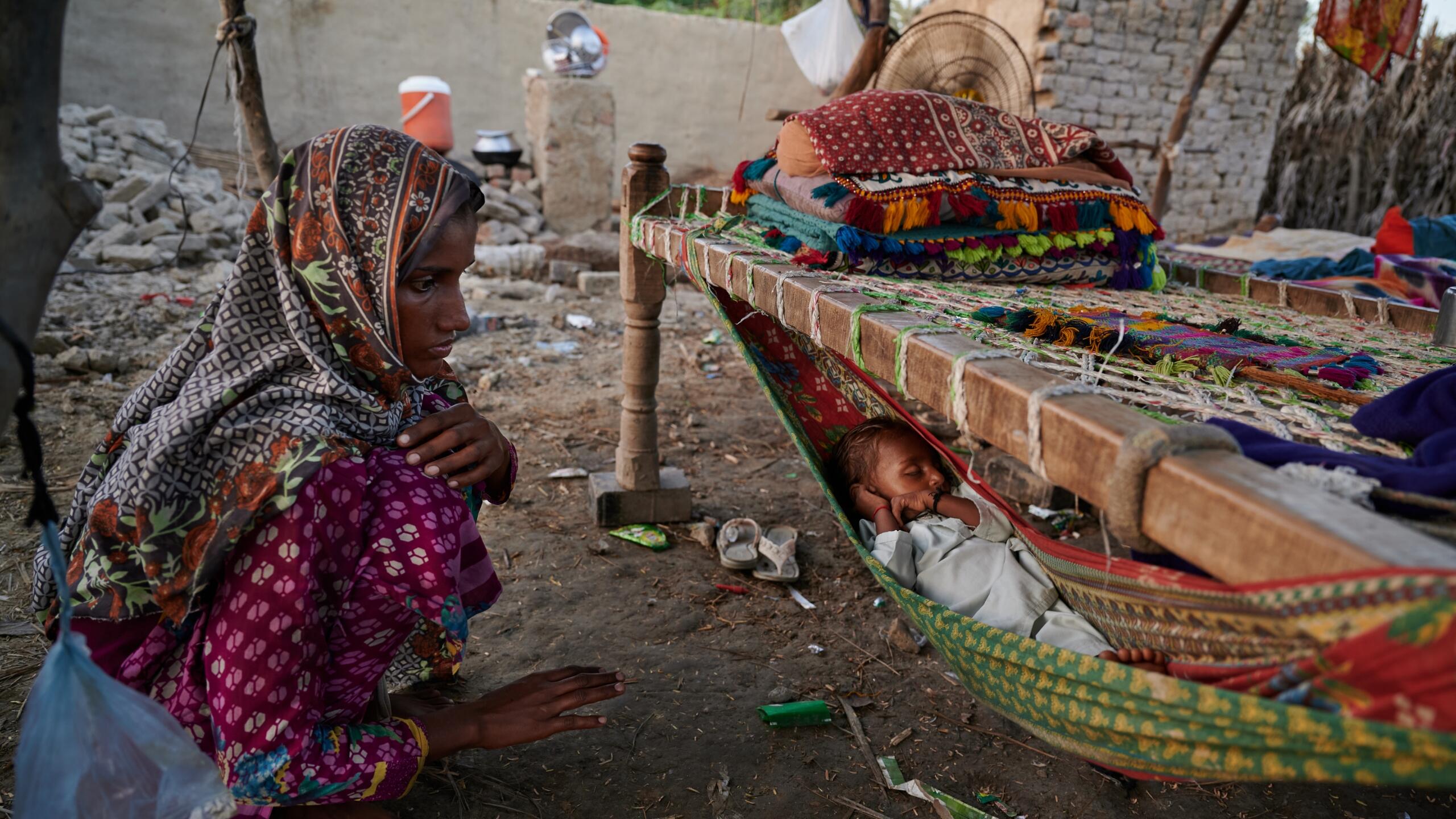 A woman sits with her sleeping child.