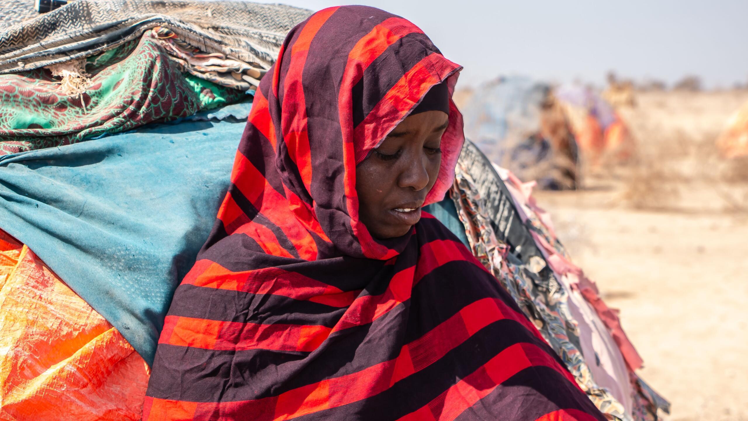 A young woman sits.