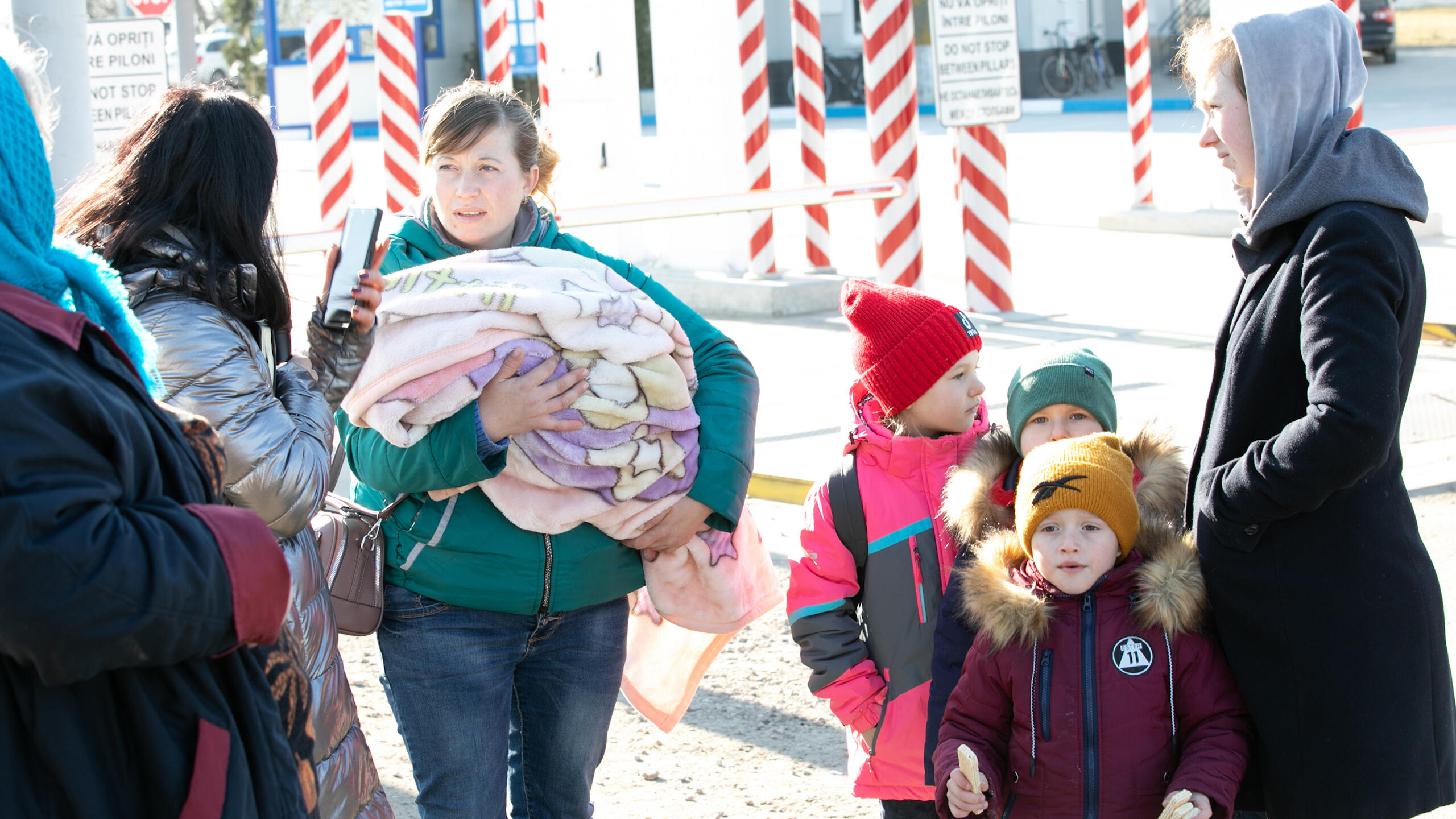 A mother stands with her children.