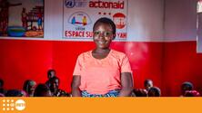 Young girl in pink t-shirt looks at camera and smiles