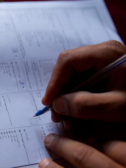 Una mano escribe en un documento del censo.