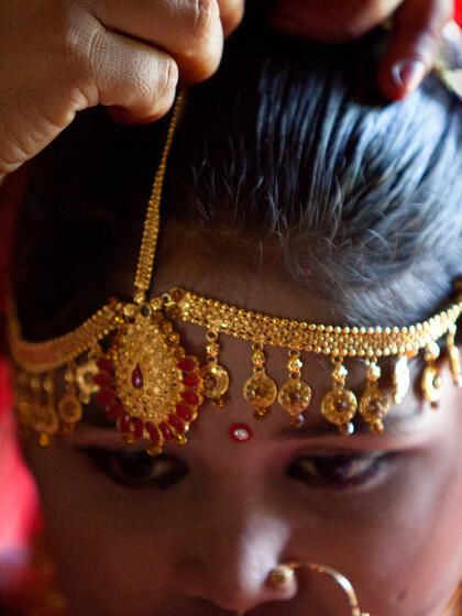 Une jeune fille est vêtue de bijoux.