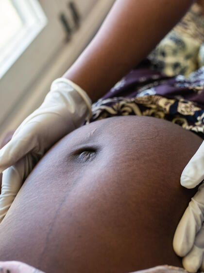 Un trabajador médico examina a una mujer embarazada.